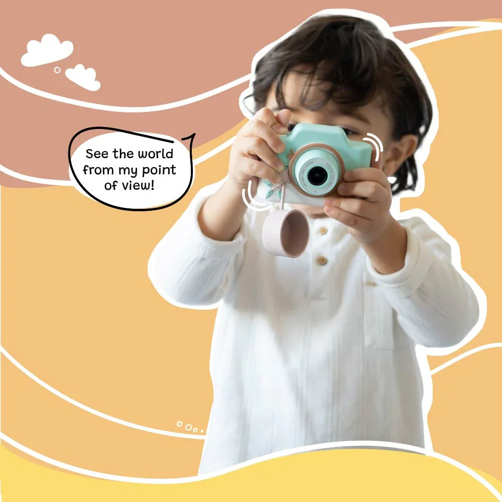 Young child holding and using kiimento Model K Zippy the Sloth kids digital camera with lens cap hanging, showcasing a child’s point of view