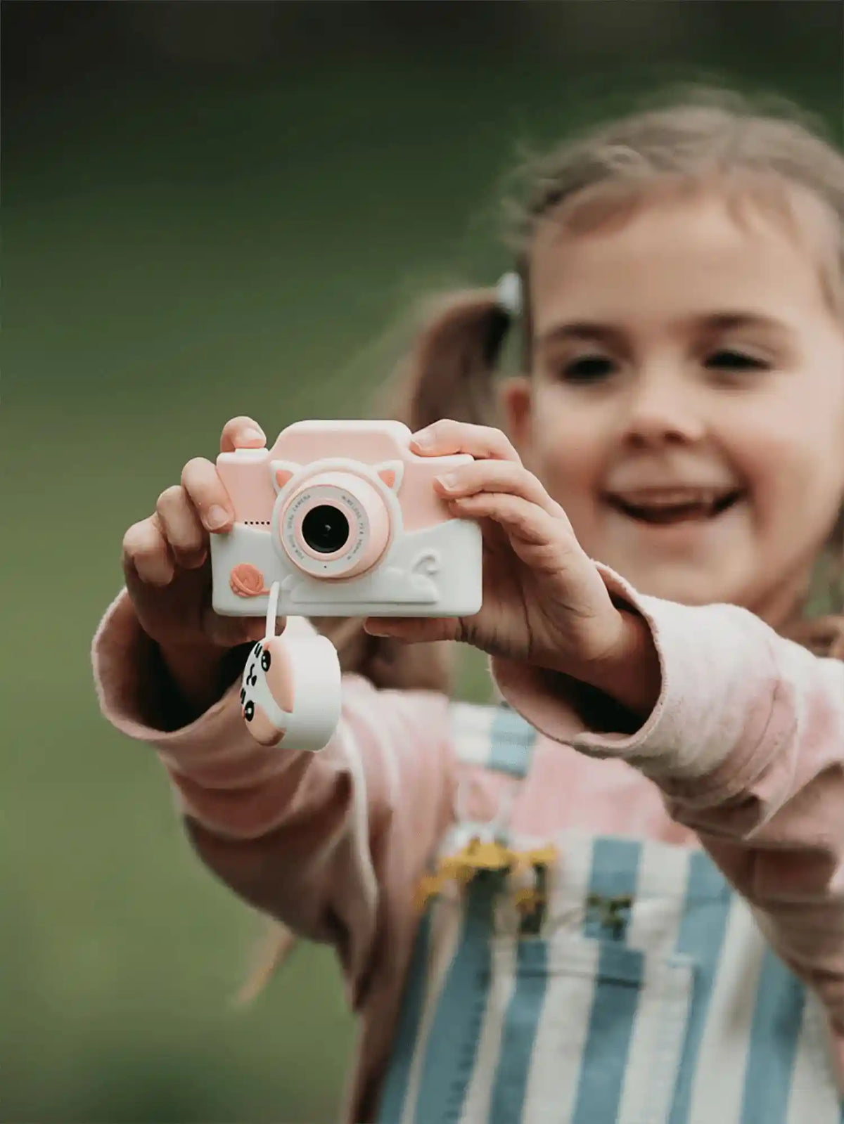 Girl using kiimento Cat Digital Camera Model K outdoors – pink silicone cat-design kids touchscreen camera