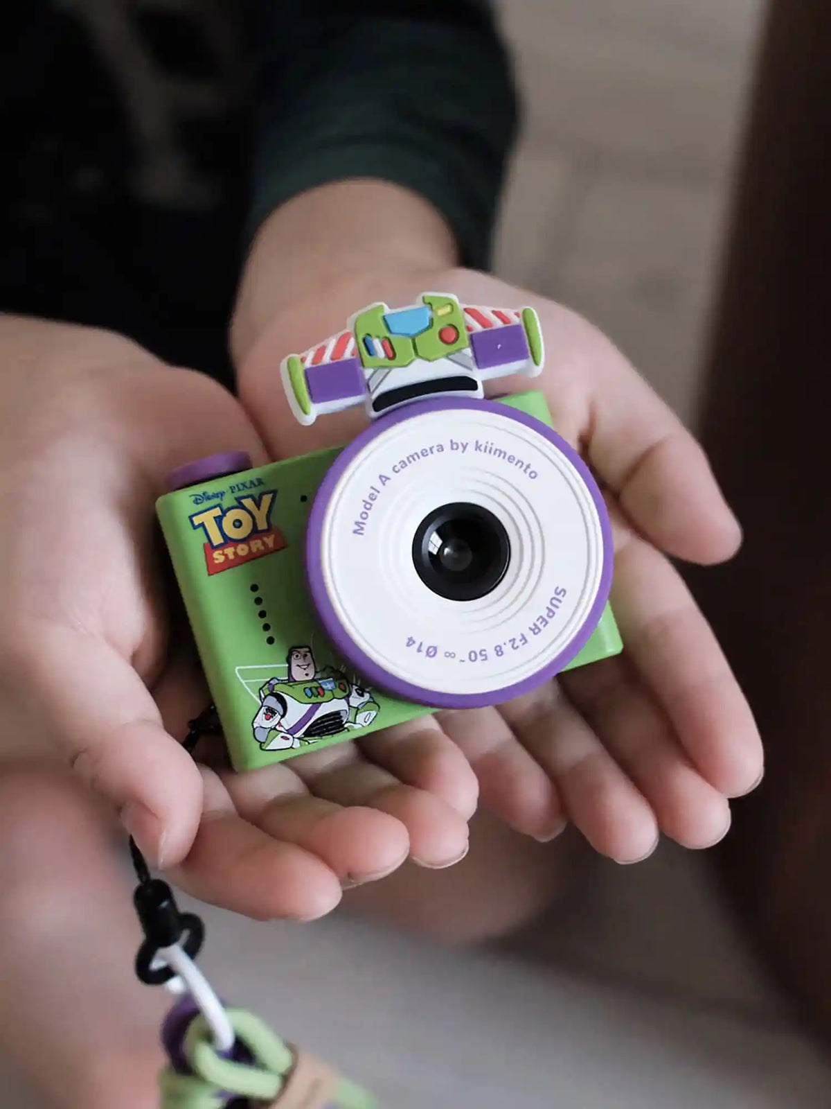 Hands holding kiimento Disney Buzz Lightyear Mini Camera Model A – green Toy Story Buzz mini kids camera